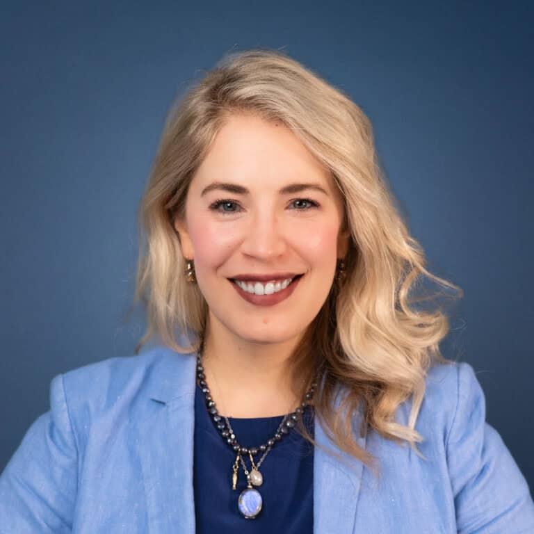 Kelly Kruse headshot, blonde woman smiling in a blue blazer.