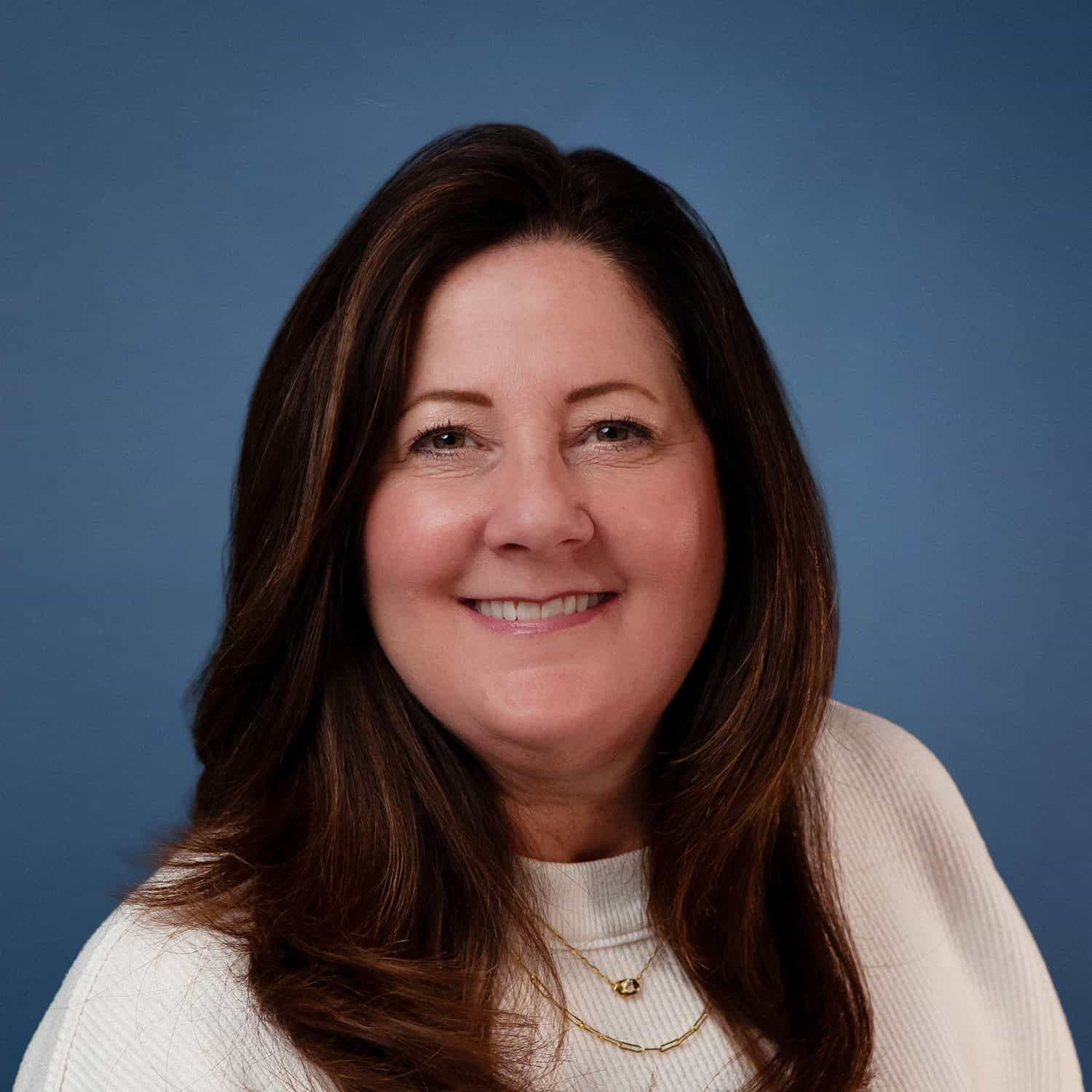 Portrait of Kelly Stein smiling against a blue background.
