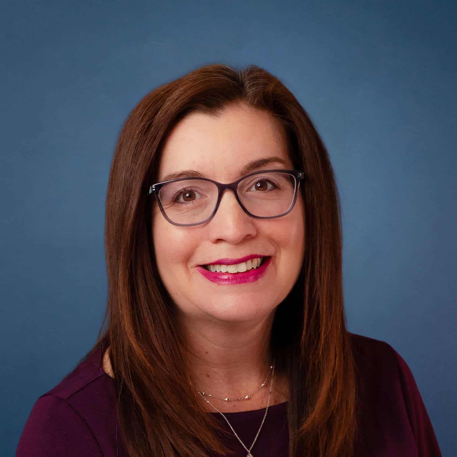 Headshot of Sara Spence, smiling woman with glasses and auburn hair.