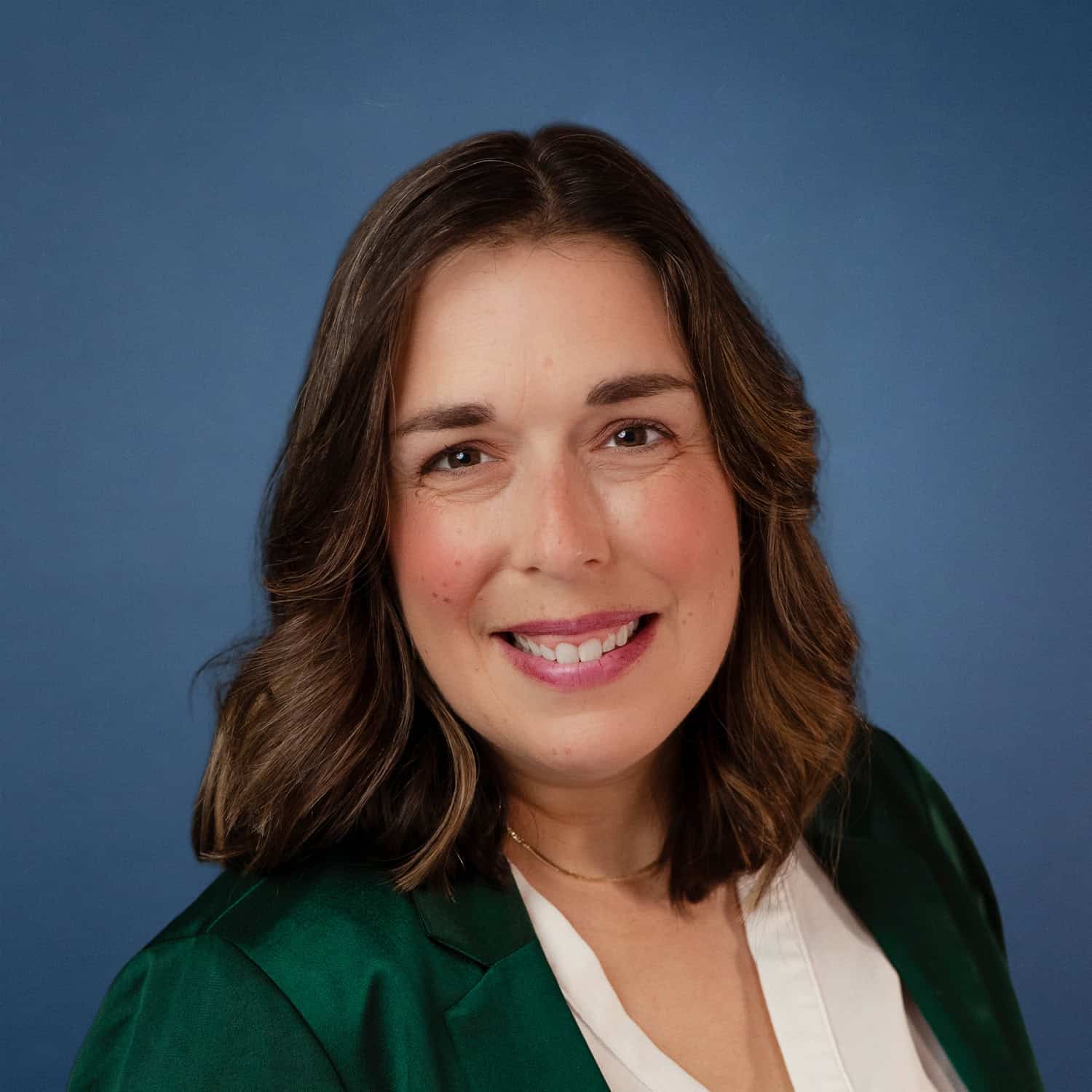 Amy Zoellner headshot. Smiling woman with brown hair wearing a green blazer.