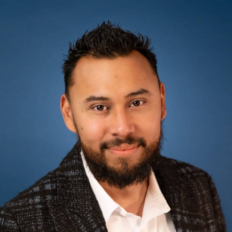 Gabriel Perez portrait. Man with a beard wearing a blazer and white shirt.