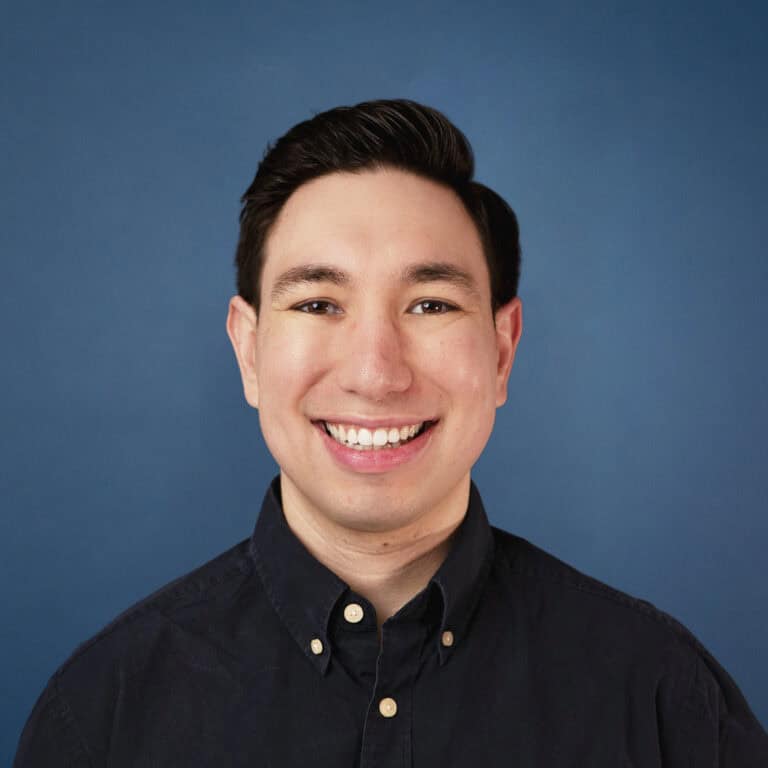 Headshot of Jacob Nannie smiling against a blue background.