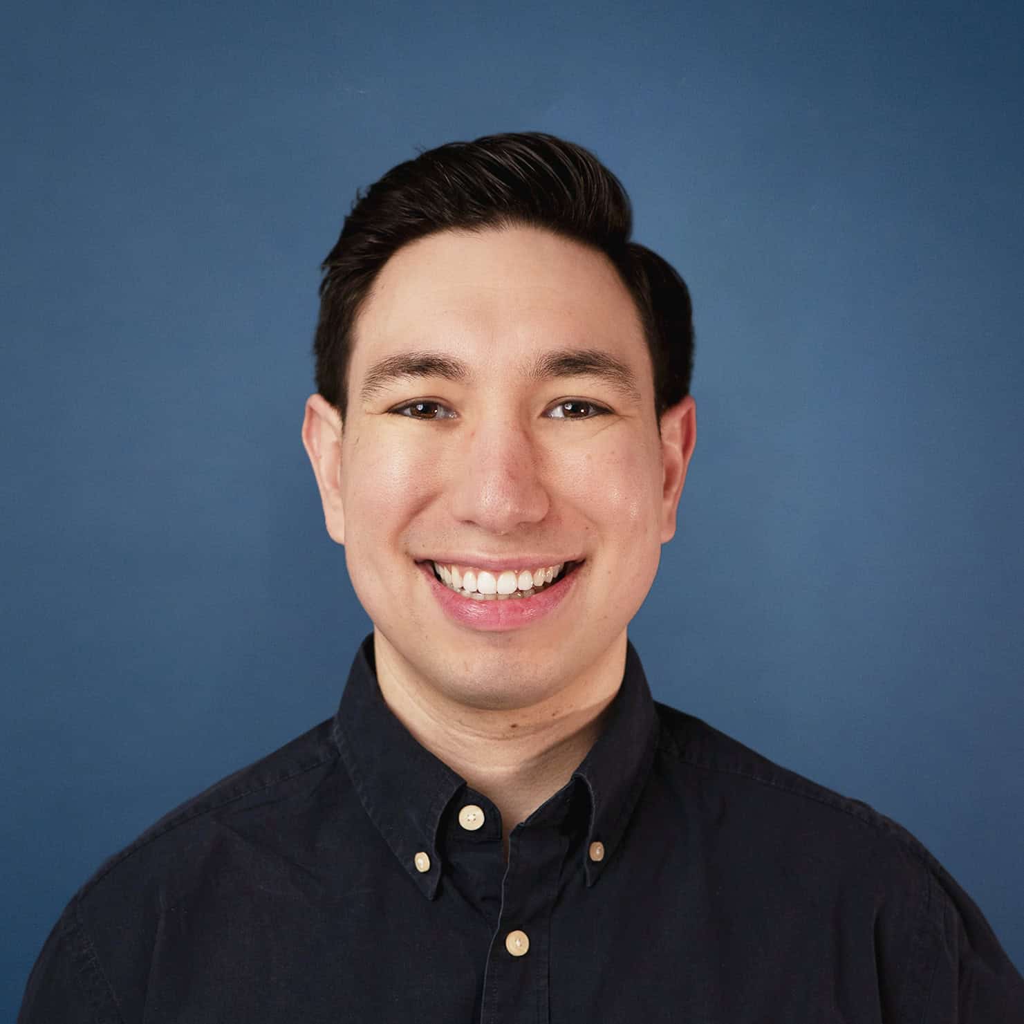 Headshot of Jacob Nannie smiling against a blue background.