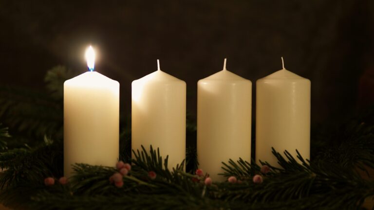 Advent wreath with one candle lit, symbolizing hope and anticipation.
