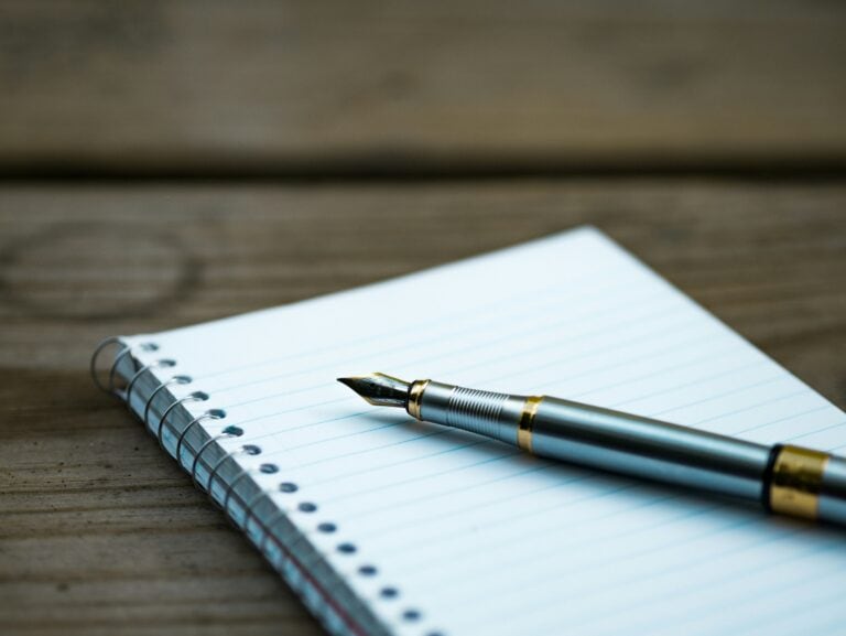 Fountain pen on a lined notepad, ready for writing. New home planning.