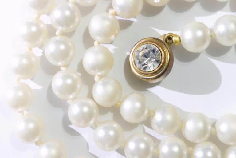Elegant pearl necklace with a jeweled clasp, showcasing ancient literature themes.