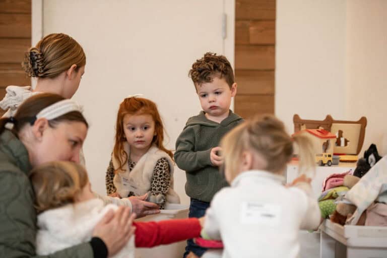 Children at Brookside Campus play with toys alongside caregivers.