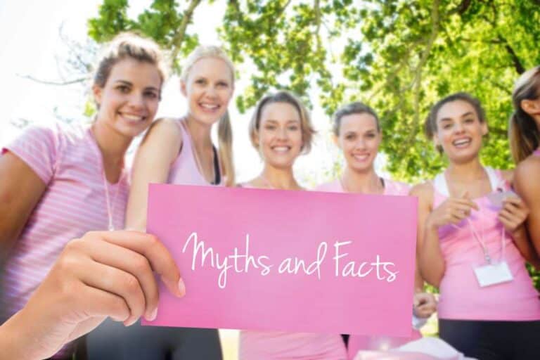 Women in pink holding "Myths and Facts" sign.