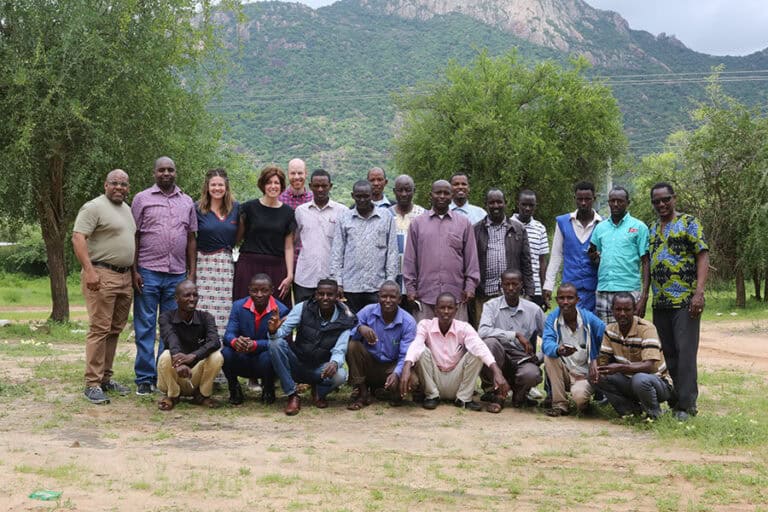 Group photo of Outreach participants with mountains in the background.