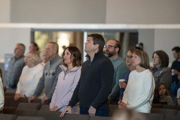 Olathe Campus: People stand in church during service, looking toward the stage.