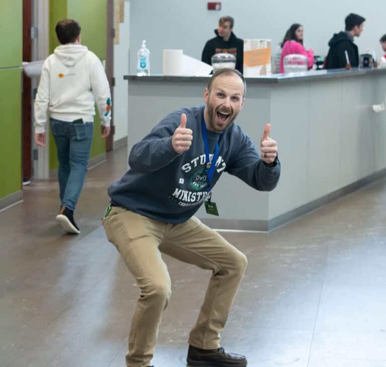 Enthusiastic man gives thumbs up at Leawood Campus. "Student Ministries" visible on his lanyard.
