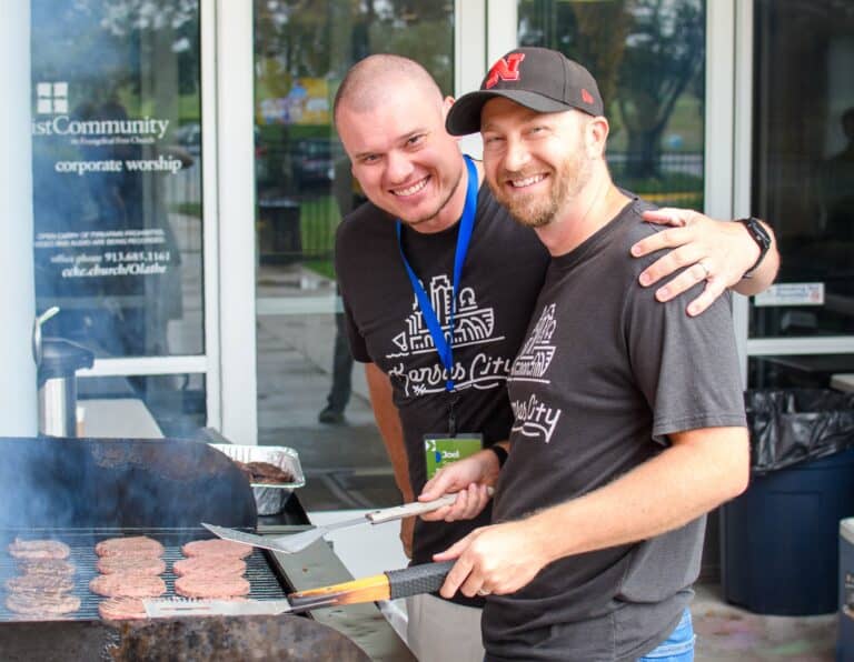 Two men grilling burgers at Christ Community Church's Olathe Campus. Community event.