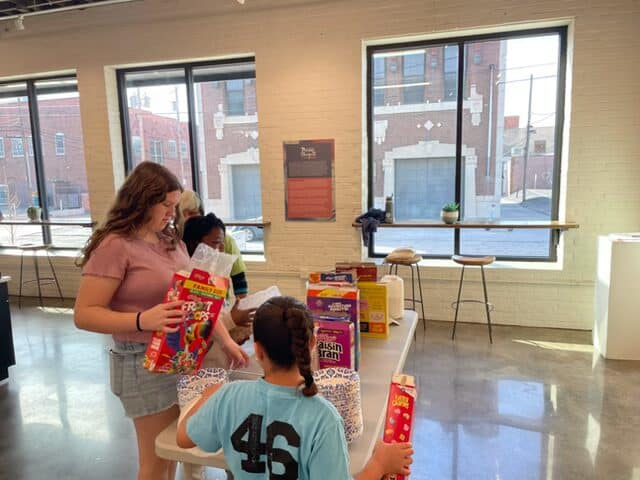 People packing cereal boxes at Downtown Campus event.