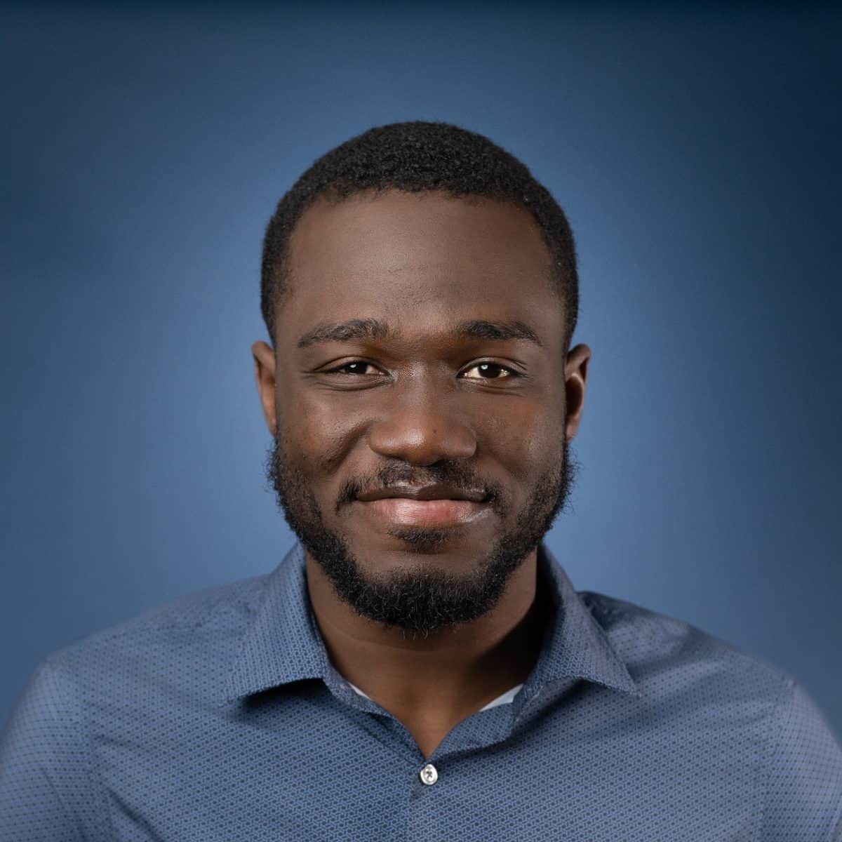 Headshot of Benjamin Asante smiling against a blue background.